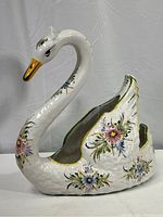 Full view of white ceramic swan-shaped vase with hand-painted flower patterns.