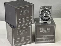 Three Prédiré Paris skincare boxes and one open jar with a silver spherical container inside clear square outer packaging.