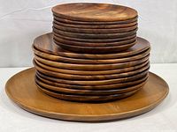 Stacked wooden platter and plates showing size variation and wood grain.