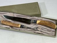 Carving knife and fork set in original green satin-lined box, showing both pieces side by side