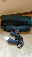 Wind River binoculars and Alpen spotting scope telescope with carrying case on floor.