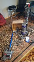 Overall view of two upright vacuums, attachments, and filters on floor
