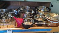 Overview photo showing most cookware items including stainless steel and copper pots, mixing bowls, funnel, and rack