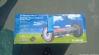 Front view of the boxed 18-inch push reel mower with product branding and images on the packaging.