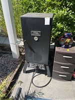 Masterbuilt Sportsman Elite smoker showing front with temperature gauge and control panel on base