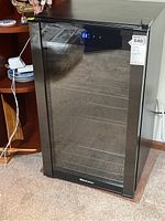 Full front view of upright wine fridge showing glass door and cabinet