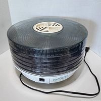 Front view of the six tray food dehydrator with power cord and Home Trends branding on the base.