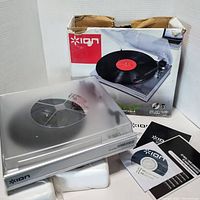 ION Power Play LP vinyl record player with clear dust cover and original box with accessories including software CD and user manuals.