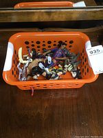 Basket filled with various action figures including barbarian knight, wolf, and others in mixed poses.