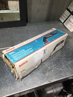 Image of Bosch B7000 corner/detail sander in original box on a table.