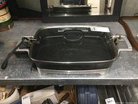 Full view of the Hamilton Beach electric frying pan on countertop, showing overall condition and design with glass lid locked down.