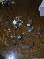 Overview of 9 ladies vintage watches on wooden table showing variety of bracelet styles and dial shapes, some gold and silver tone