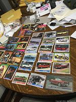 Full view of collection of vintage Mustang car trading cards and rockstar cards displayed on table