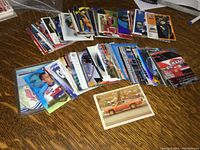 Photo showing multiple NASCAR racing cards laid out fanned across a tabletop with various colors and images visible.