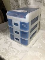 Closed plastic 3-drawer jewelry organizer showing white and translucent blue drawers.