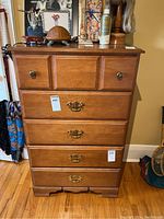 Front view showing dresser with two small top drawers and three larger drawers below with two types of metal hardware.
