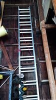 Full length view of the 10-foot aluminum extension ladder in storage, showing overall condition and surroundings.