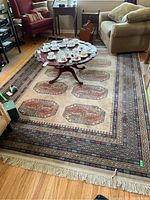 Overall view of rug under coffee table showing full layout and ivory fringe ends