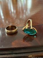 Both gold rings side by side on wood surface
