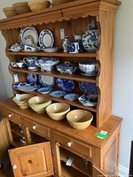 Front view of two-piece pine hutch with dishes (not included) on shelves