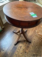 Overview of round wooden drum table showing top surface with wood grain and condition issues such as scratches and scuffs.
