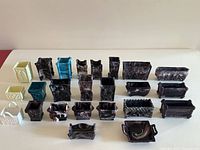 Full lot of 23 antique Sowerby malachite slag glass vases and containers arranged in rows showing variety of shapes and colors including purple, blue, yellow and white slag glass items.