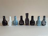 Front view of all eight slag glass vases showing color and pattern variety