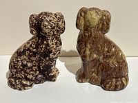 Front view of both dog figurines on white surface