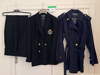 Navy blue blazer and pants hanging next to navy blue cotton jacket, showing overall presentation of women's suit and jacket set.