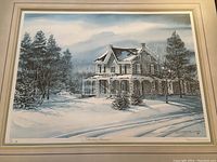 Close-up of the framed print showing the winter snow-covered house and surrounding trees in muted colors.