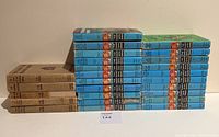 Side view of brown and blue hardcover Hardy Boys books stacked showing spines and series numbers