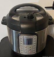 Front view of Instant Pot Duo Plus showing digital control panel and pressure release valve on lid.