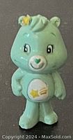 Photo of miniature PVC Care Bear figurine in light green with star emblem on belly and tuft of hair