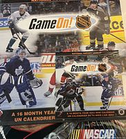 Front view of sealed large NHL 2002 calendar and pocket calendar showing 'Game On!' NHL branding and various player images.