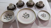 Complete set arranged showing cups and saucers, dinner plates, soup bowls, and bread plates with shamrock design on white background