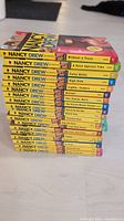 Stacked spines view showing titles and numbers 1-17, 20 and 24 of Nancy Drew Girl Detective series books.