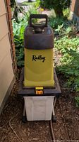 Front side view of the Radley wood chipper showing yellow body, handle, and white collection bin.