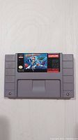 Front view of the Super Nintendo Mega Man X game cartridge showing label with artwork and branding.