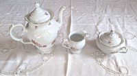 Overall view of the Wawel China tea and coffee set showing coffee pot, creamer, and sugar bowl on white lace tablecloth