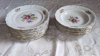 Stack of 9 luncheon plates and 8 soup bowls showing floral designs and gilt trim