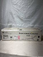 View of unopened white box labeled Canarmna Industrial Ceiling Fan with product details visible.