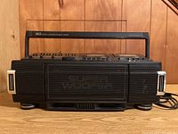 Front view of boom box showing SUPER WOOFER speaker grille and handles on both sides