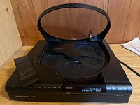 Top-down view of the Harman/Kardon TL-8500 5-CD changer with open lid showing the disc carousel and remote placed on player.