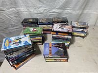 Photo showing multiple stacks of DVDs including animated children’s movies and various other titles