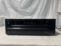 Front view of Onkyo HT-RC430 AV receiver showing power button, digital display tuned to FM 98.9 MHz, and control buttons.