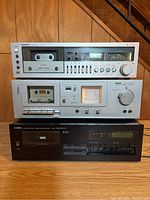 Front view of three stereo cassette decks stacked: Onkyo TA-2050 on top, Akai CS-M01 in middle, Yamaha K-960 at bottom.