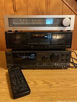 Front view of stacked Technics ST-8011 tuner on top, Pioneer CT-W403R double cassette deck in middle, and Technics SA-GX700 stereo receiver on bottom with remote on surface.