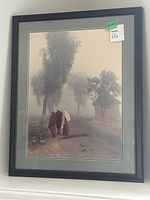 Framed signed and dated photograph showing a misty rural path with three people walking away, surrounded by trees and a small shelter.