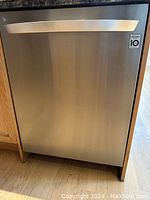 Front view of stainless steel dishwasher installed under counter