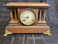 Full front view of oak mantel clock showing case, columns, feet and dial